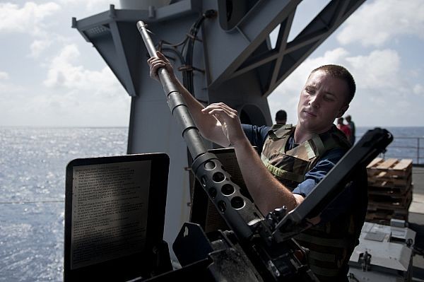 Một binh sỹ đang thay nòng cho một khẩu súng máy gắn trên bong chiến hạm USS John C. Stennis (ảnh ngày 31/8/2011).